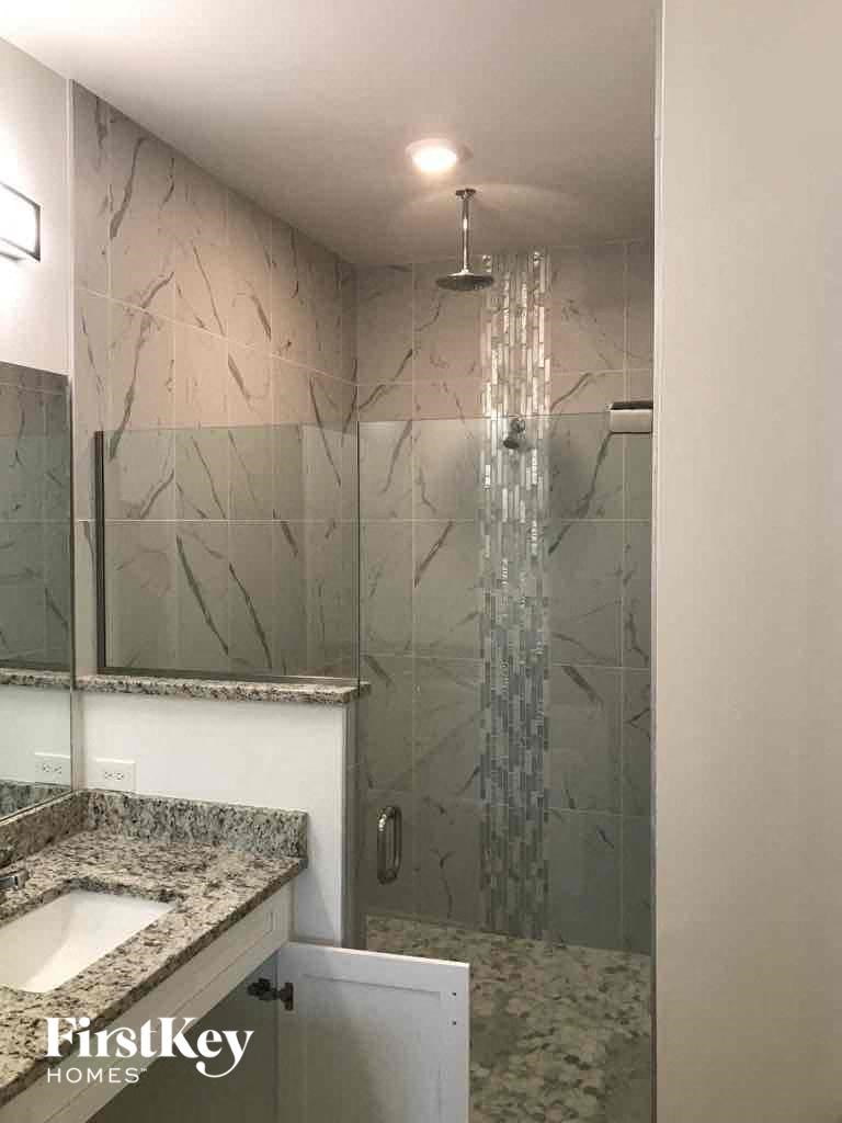 a bathroom with a shower and a sink and a mirror