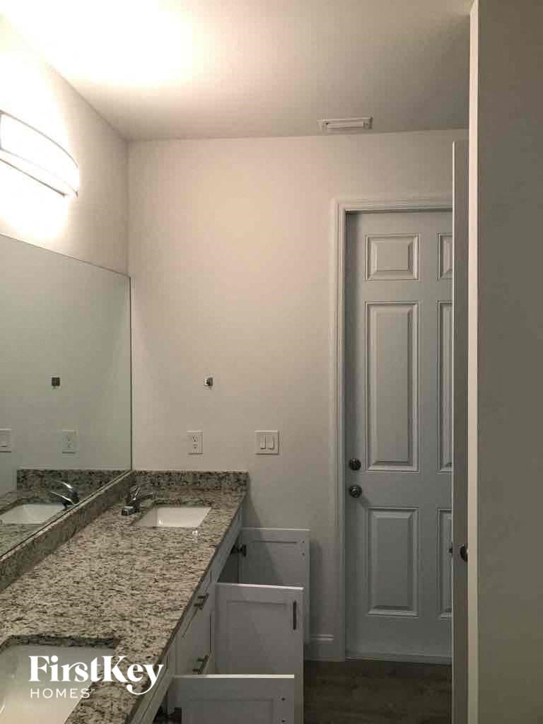 a bathroom with a sink and a mirror and a white door