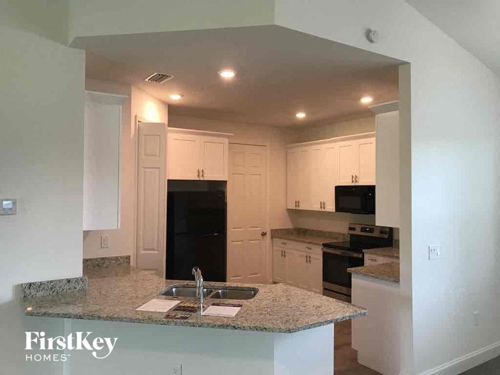 a kitchen with white cabinets and a granite counter top
