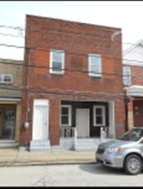 A red brick building with a white door and windows.
