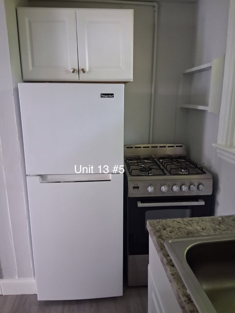 A white fridge and stove in a kitchen.