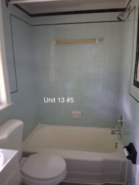 A bathroom with a toilet, sink, and bathtub.