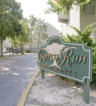 a sign for the chrysalis run apartments on the side of a street