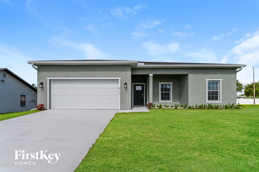 A house with a garage and a driveway in front of it.