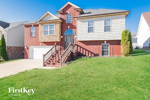 a large brick house with a front yard and stairs