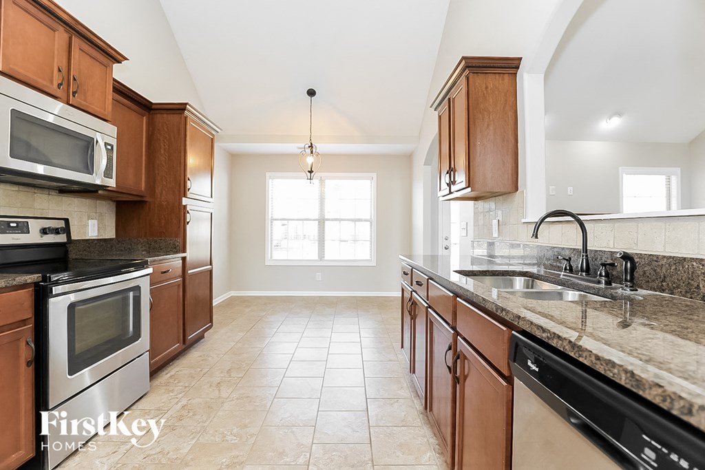 a kitchen with wooden cabinets and granite counter tops and a sink