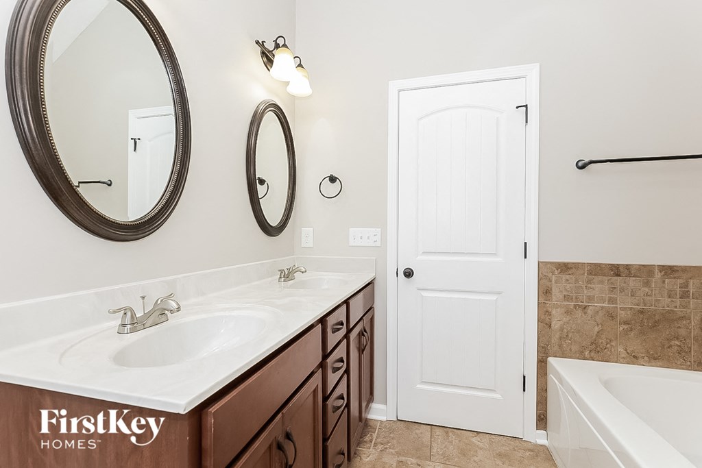 a bathroom with a sink and a mirror and a door