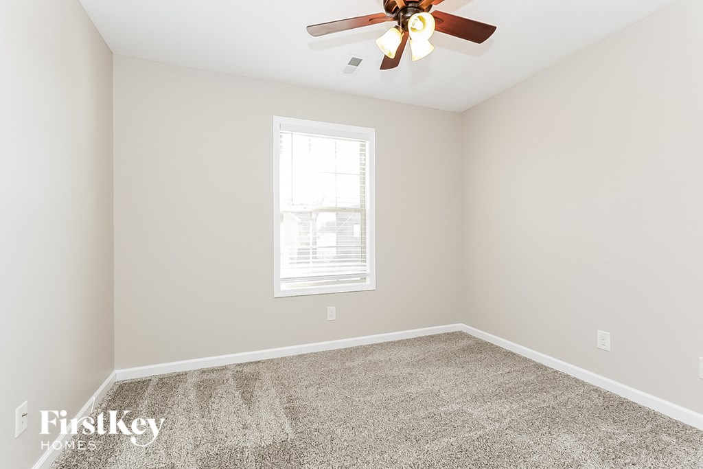 a bedroom with carpet and a ceiling fan