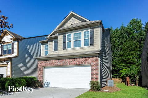 A house with a garage door is for sale by FirstKey Homes.