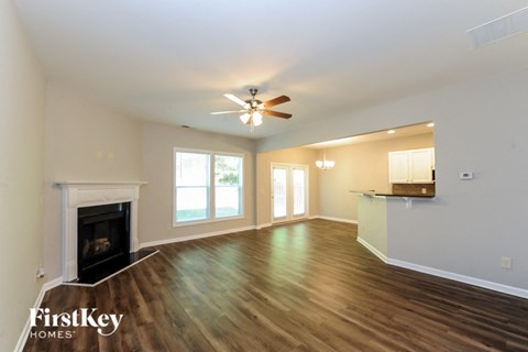 A spacious living room with a fireplace and wood flooring.