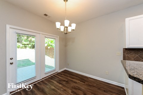 A room with a chandelier and a door leading outside.