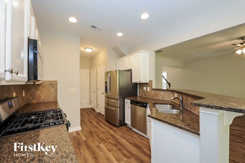 A kitchen with a stove top oven and a refrigerator.