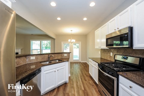 A kitchen with white cabinets and a black stove top oven.