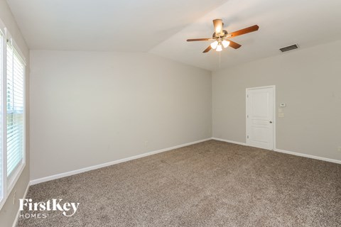 A room with a ceiling fan and a door.