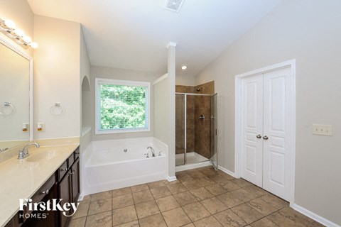 A bathroom with a tub, sink, and shower.
