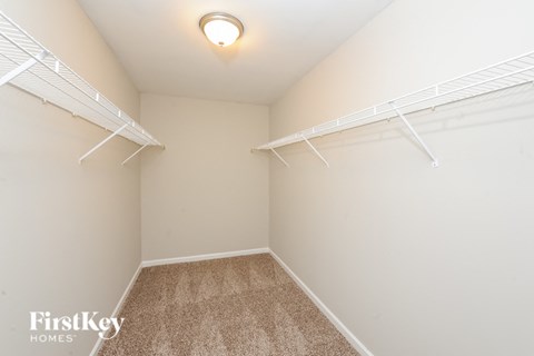 A small, empty room with a carpeted floor and white walls.