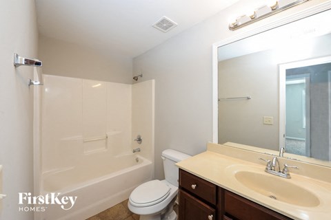 A white bathroom with a toilet, sink, and bathtub.