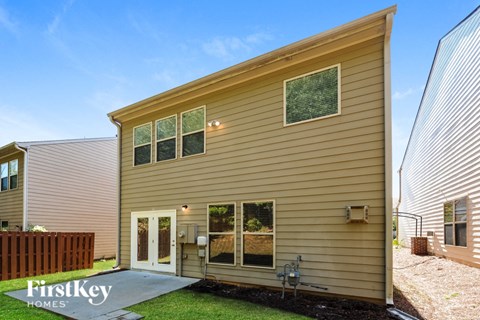 A house with a brown siding and a white door is shown.