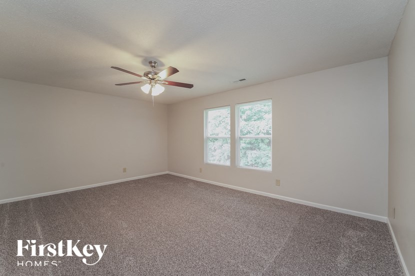 a empty room with a ceiling fan and a window