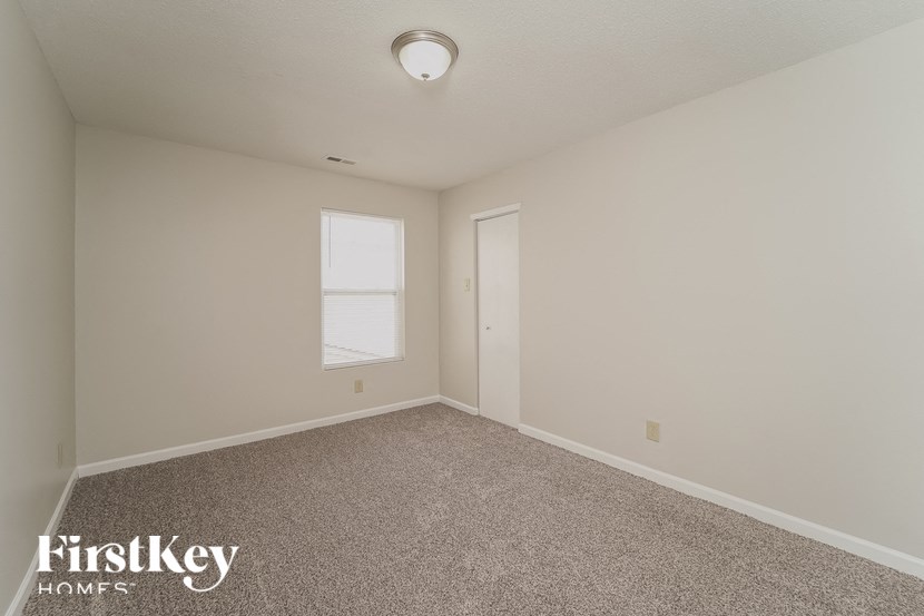 a bedroom with a carpeted floor and a window