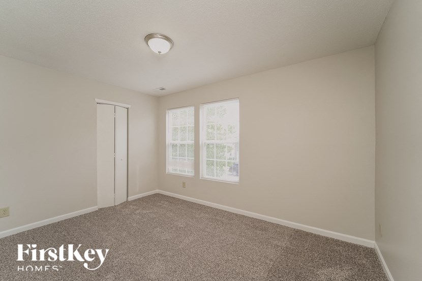 a bedroom with a carpeted floor and a door