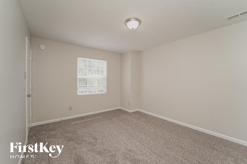 an empty room with carpet and a window