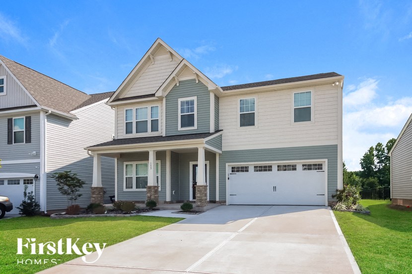 a beige house with a white garage door