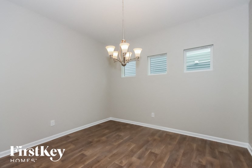 the spacious living room with wood flooring and a chandelier