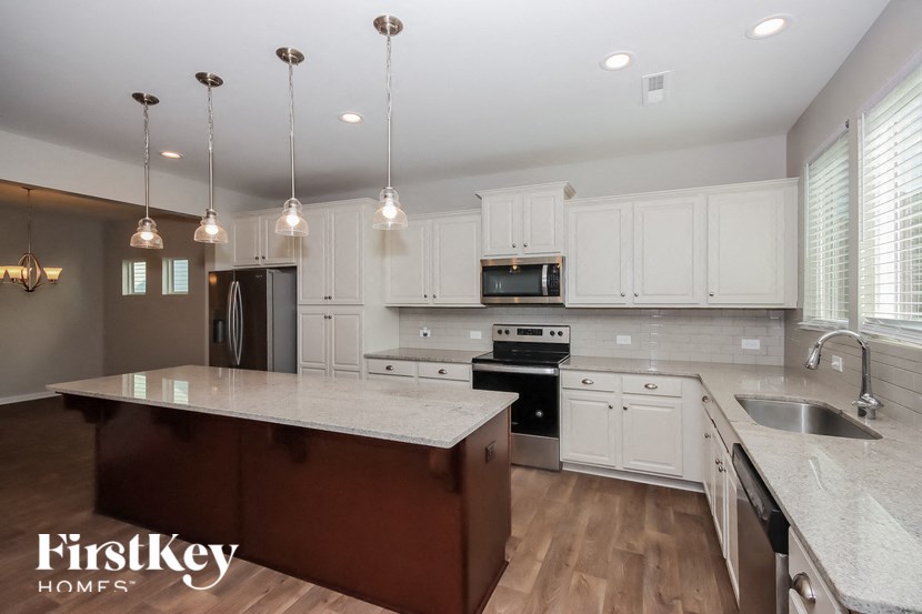 a large kitchen with white cabinets and stainless steel appliances