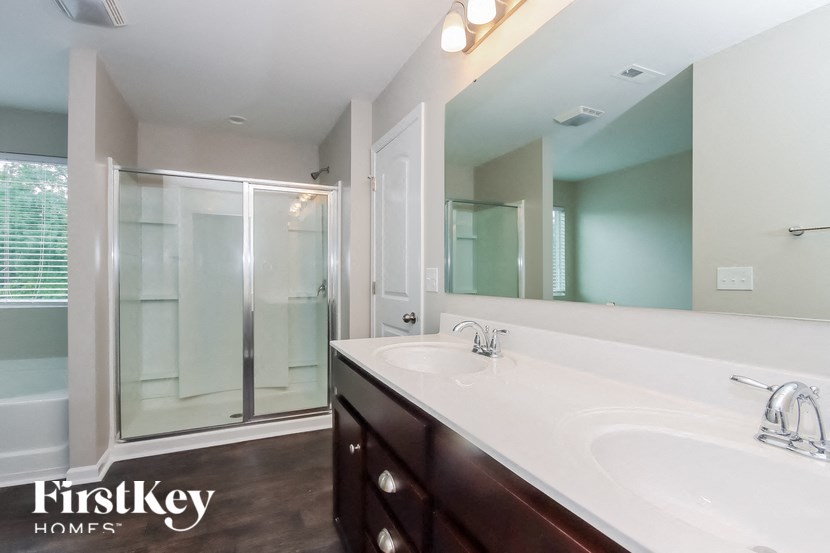 a bathroom with a large mirror and a sink and a shower