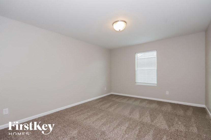 the upstairs bedroom with carpet and a window
