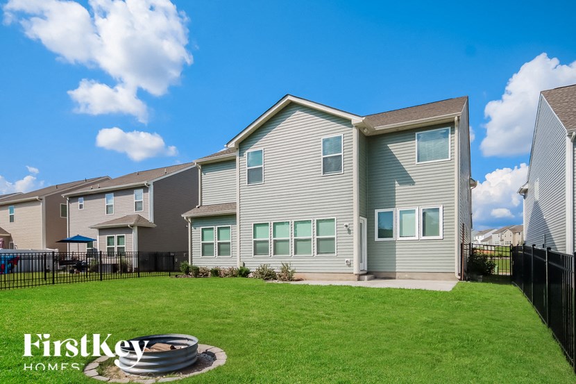 a house with a yard and a tire in the grass