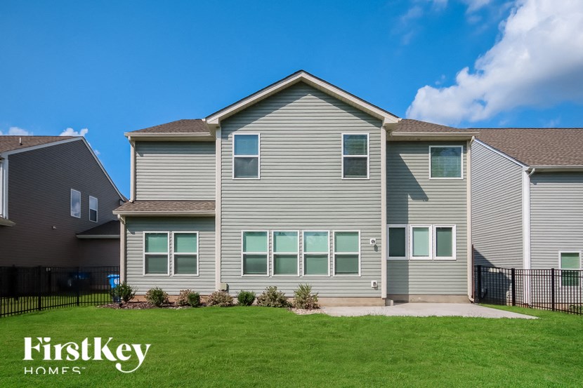 a gray house with a yard in front of it