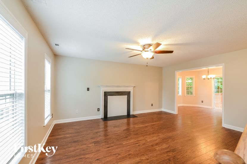 a living room with a fireplace and a ceiling fan