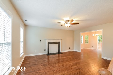 a living room with a fireplace and a ceiling fan