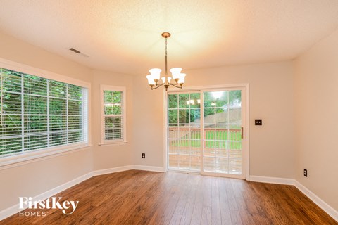 a dining room with wood floors and a large window