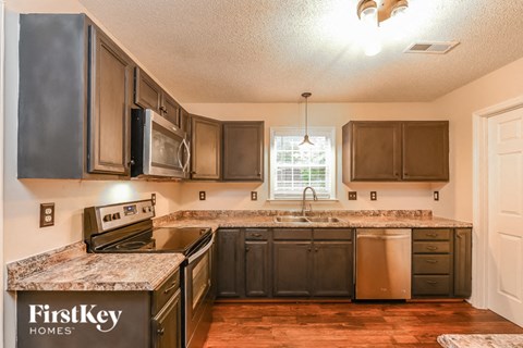 a kitchen with dark wood cabinets and granite counter tops