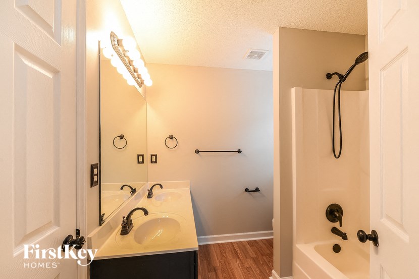 a bathroom with a sink and a shower and a mirror