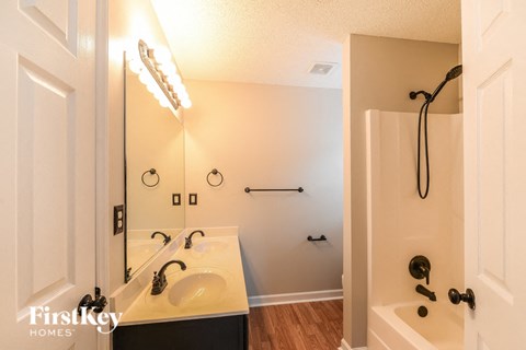a bathroom with a sink and a shower and a mirror