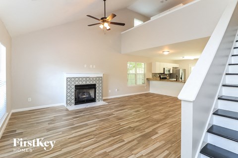 A spacious living room with a fireplace and wooden flooring.