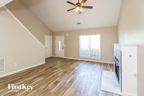 A spacious room with a ceiling fan and wooden flooring.
