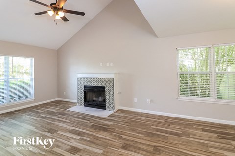 A room with a fireplace and wood flooring.