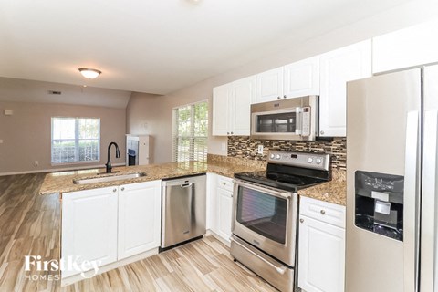 A kitchen with white cabinets and stainless steel appliances.