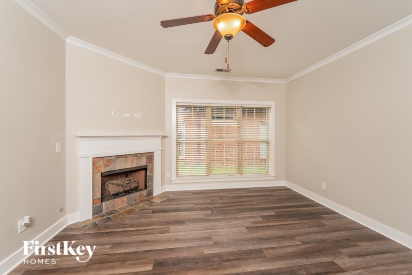 A room with a fireplace and a ceiling fan.