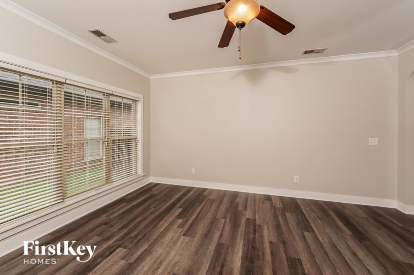 A room with a ceiling fan and wooden flooring.