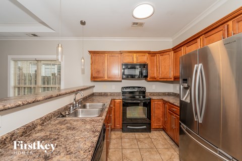 A kitchen with wooden cabinets and a stainless steel refrigerator.