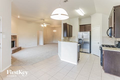 A kitchen with a white island and a refrigerator.
