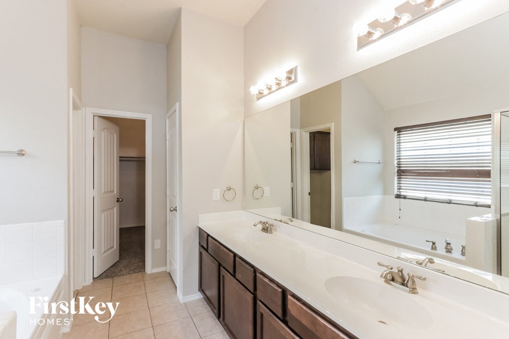 A bathroom with a large mirror and a sink.