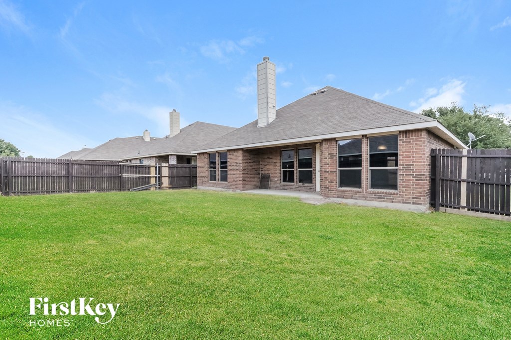 A house with a fence and a grassy yard.