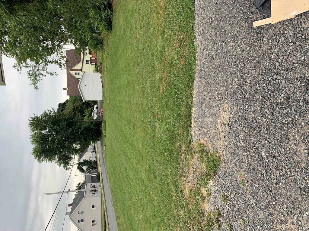 an aerial view of a grassy field next to a street